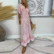 Full-length view of woman in flowing pink boho maxi dress with floral block print and decorative border detailing