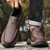 Black leather moc-toe slip-on shoe with lugged sole, side view