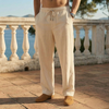 Man wearing khaki linen drawstring pants standing on a terrace