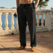 Man wearing black linen drawstring pants standing on a terrace