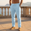 Man wearing light blue linen drawstring pants standing on a terrace