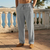 Man wearing gray linen drawstring pants standing on a terrace