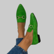 Green suede-look moccasin flats on a model's feet