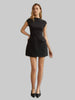 Woman wearing a black cap sleeve A-line mini dress with flap hip pockets