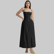 Woman wearing a black corset-style midi dress with gathered skirt