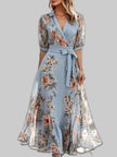 Women's light blue floral print chiffon maxi wrap dress with V-neck and self-tie belt on grey background