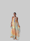 Woman wearing a multicolor watercolor print halter maxi dress with an open back