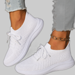 White lace-up sneakers on a model's feet