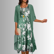 Woman wearing dark green layered two-piece midi set with sheer open-front cardigan and white floral print slip dress