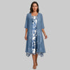 Woman in blue floral layered midi dress set with sheer cardigan over slip dress, gray studio background