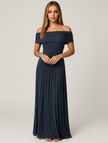 Woman wearing a navy blue off-shoulder pleated maxi dress