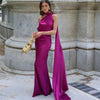 Woman wearing a magenta purple one-shoulder evening gown with a draped sash