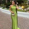 Woman wearing a lime green one-shoulder evening gown with a draped neckline