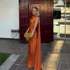 Woman wearing an orange one-shoulder evening gown with a draped shoulder sash
