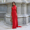 Woman wearing a red one-shoulder evening gown with a draped halter neckline