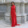 Woman wearing a red one-shoulder evening gown with a draped halter neckline