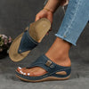 Blue wedge sandal with laser-cut strap held up by hand