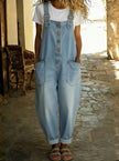 Woman wearing a light blue denim overall jumpsuit over a white t-shirt