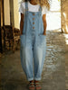 Woman wearing a light blue denim overall jumpsuit over a white t-shirt
