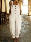Woman wearing a white denim overall jumpsuit with button-front placket