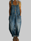 Woman wearing a medium-wash denim overall jumpsuit with buckle straps and front pockets