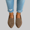 Woman's feet in cropped jeans wearing khaki suede pointed-toe penny loafers