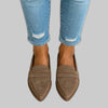 Woman's feet in cropped jeans wearing khaki suede pointed-toe penny loafers
