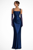 Woman wearing a navy blue satin evening gown with matching sheer gloves