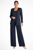 Woman wearing a navy blue sequin jacket, camisole, and wide-leg trouser three piece set