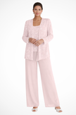 Woman wearing a light pink sequin jacket, camisole, and wide-leg trouser three piece set