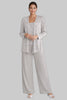 Woman wearing a silver sequin jacket, camisole, and wide-leg trouser three piece set