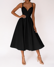 Woman wearing a black V-neck midi dress with spaghetti straps