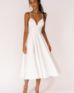 Woman wearing a white V-neck midi dress with spaghetti straps