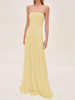Woman wearing a pale yellow strapless pleated maxi dress