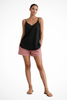Woman wearing a black linen spaghetti strap top with pink shorts