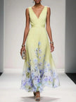 Women's V-Neck Floral Dress Maxi in Yellow — full length runway view with soft purple and blue floral border hem