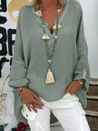 Woman wearing a gray-green oversized V-neck top