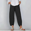 Model in black relaxed wide leg casual pants with overlapping cropped hemline, styled with white top