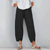 Model in black relaxed wide leg casual pants with overlapping cropped hemline, styled with white top