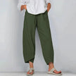 Model in olive green wide leg casual pants with asymmetric cropped hemline, styled with white shirt